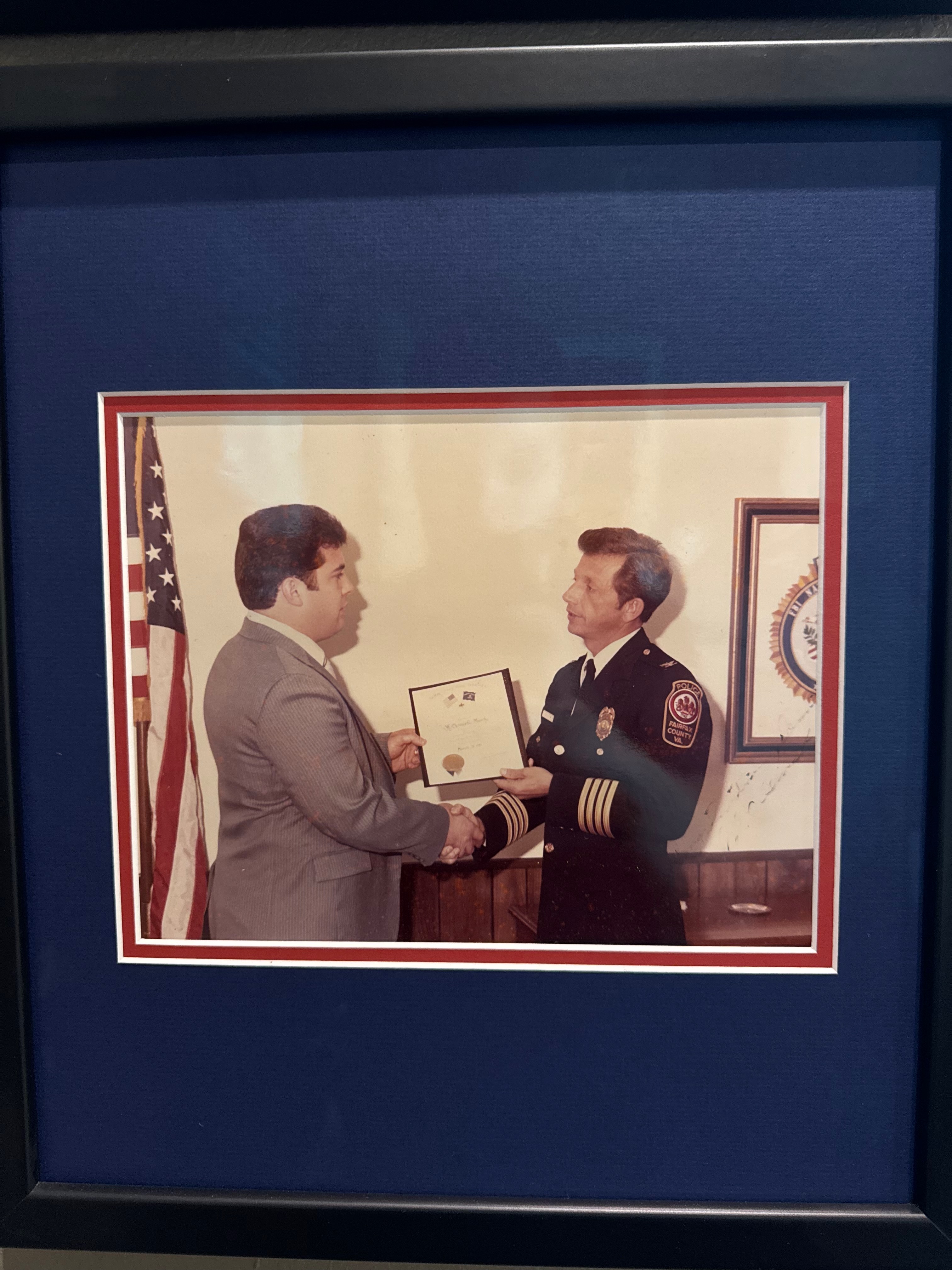 Officer Dennis R. Mundy receives the Meritorious Action Award from Chief Carroll D. Buracker, Fairfax County Police Department, 1981.